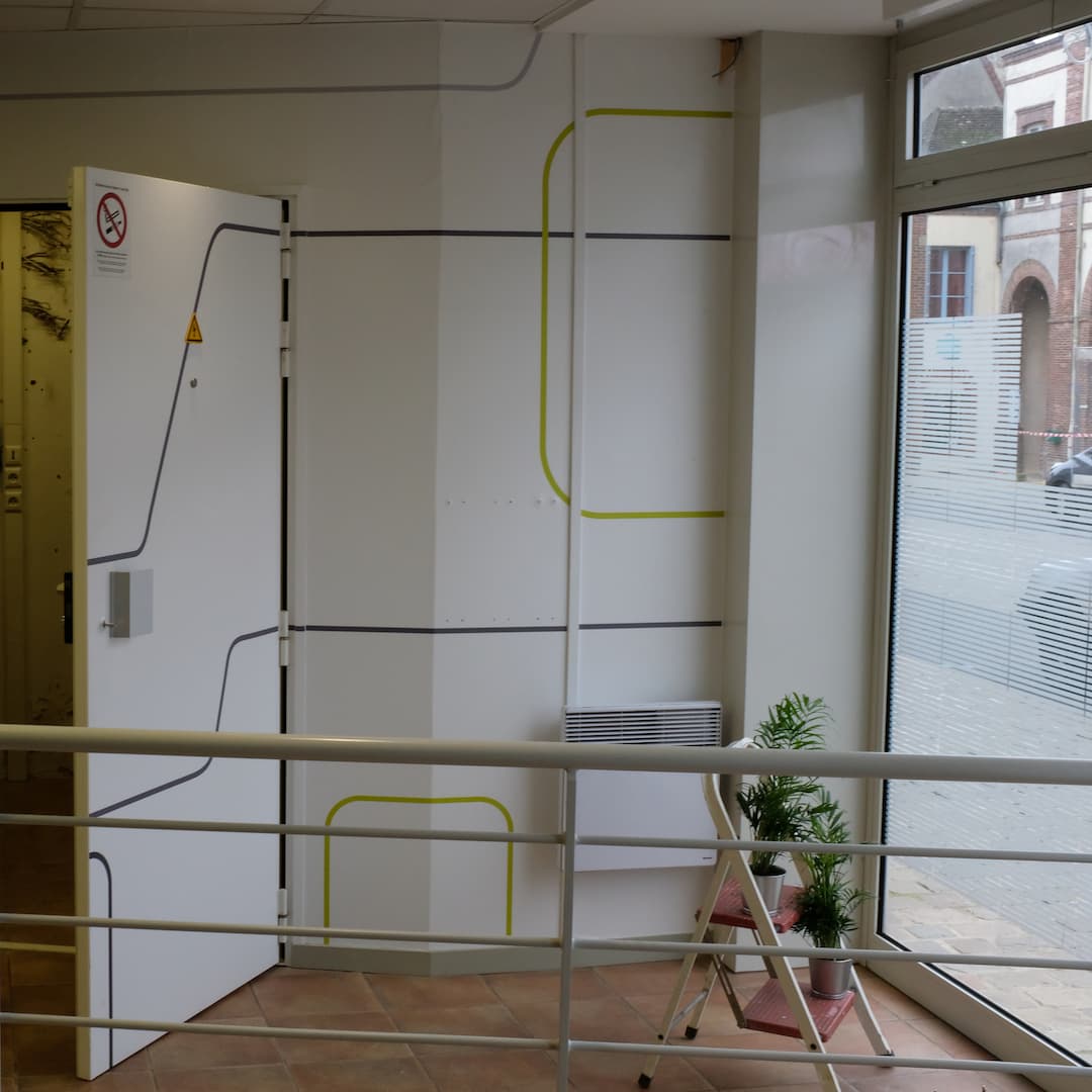 Chambre forte ouverte jouxtant la vitrinne ornée de plantes vertes